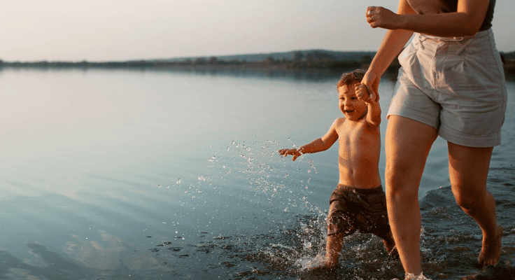 enfant avec femme courant dans l'eau